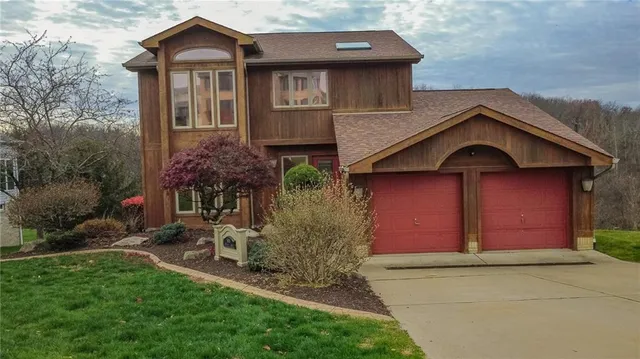 an aerial view of a house with a garden and pathway