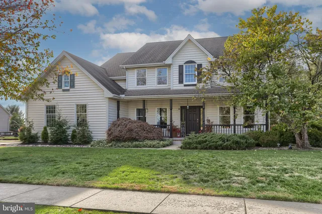 a front view of a house with a yard and potted plants