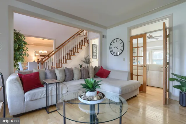 a living room with furniture a clock and a potted plant