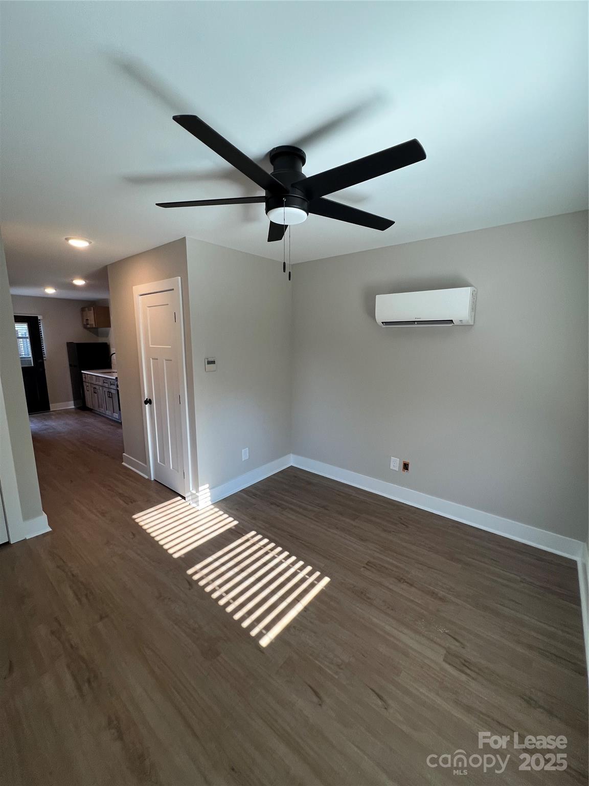 402 North 4th Street Albemarle, NC 28001 - Photo 7 of 19 a view of an empty room with wooden floor and a ceiling fan