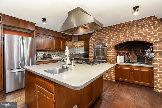 a dining room with stainless steel appliances granite countertop a kitchen island a stove a table and chairs
