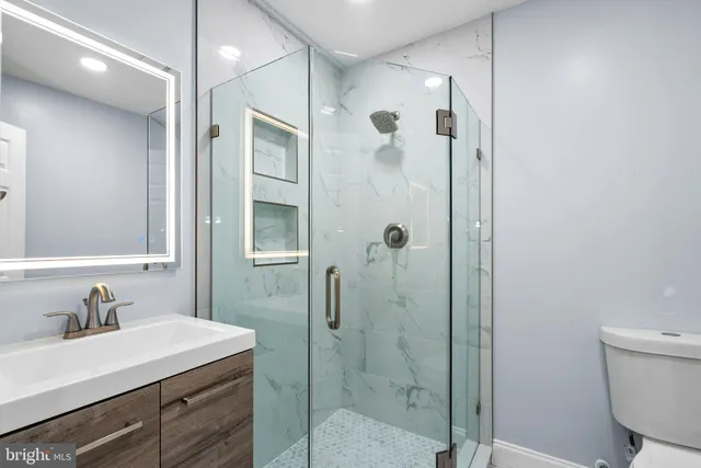 a bathroom with a shower sink vanity and mirror