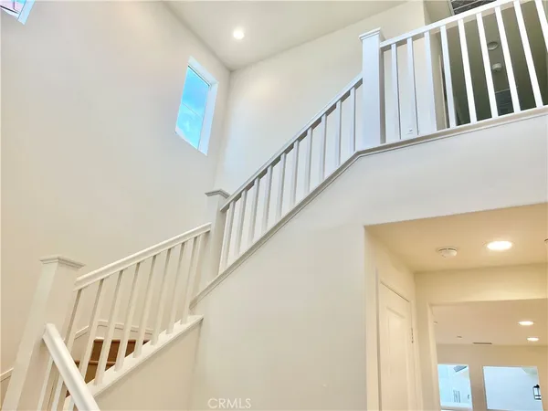 a view of staircase with lots of frames on wall and a window
