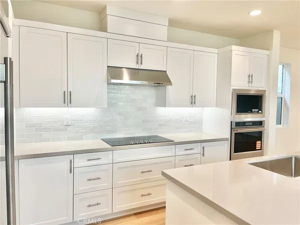 a kitchen with granite countertop white cabinets and white appliances