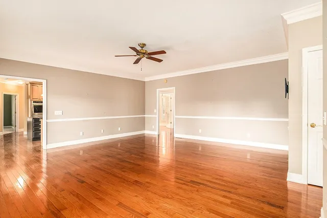 a view of empty room with wooden floor