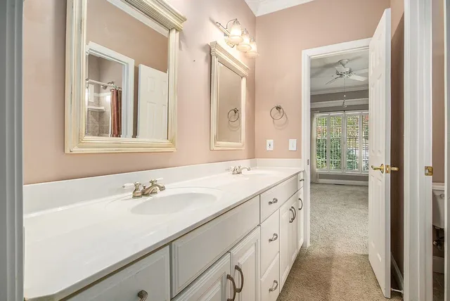 a bathroom with a double vanity sink mirror and next to a window