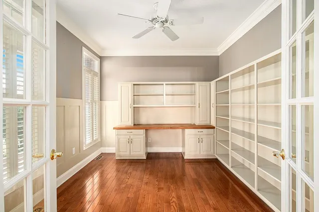 a view of an empty room with a window and wooden floor