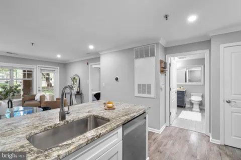 a kitchen with granite countertop a sink and a refrigerator