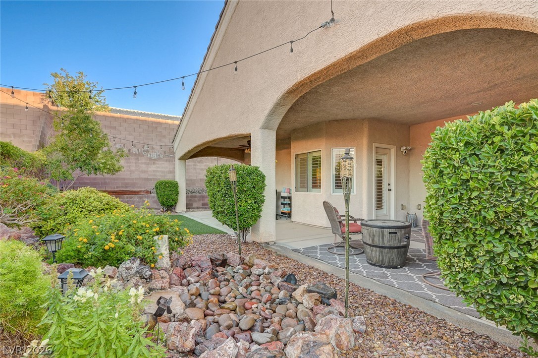1604 Cattle Ranch Place Henderson, NV 89002 - Photo 79 of 99 A spacious covered patio invites relaxation amidst a xeriscaped backyard with lush plantings.
