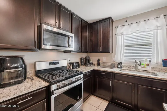 a kitchen with stainless steel appliances granite countertop a sink stove microwave and cabinets