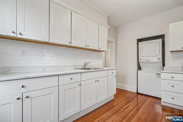a kitchen with granite countertop white cabinets and sink