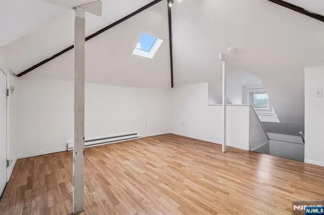 an empty room with wooden floor and entrance