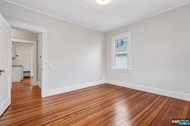 a view of a room with wooden floor and a hallway
