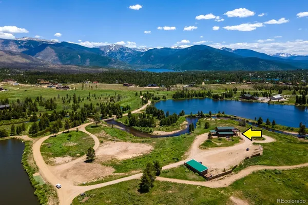 an aerial view of a house with a garden and mountains