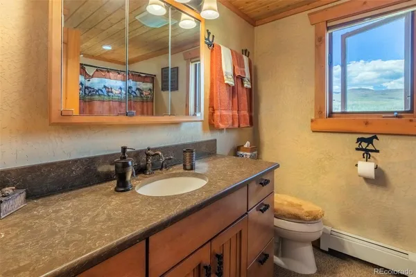 a bathroom with a granite countertop sink mirror vanity and toilet