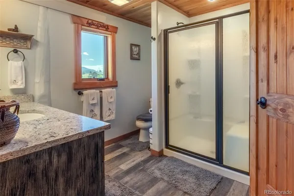 a bathroom with a granite countertop sink a toilet and shower