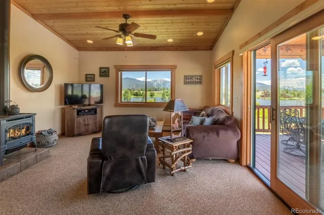 a room with furniture a chandelier a large window with flat screen tv and couches