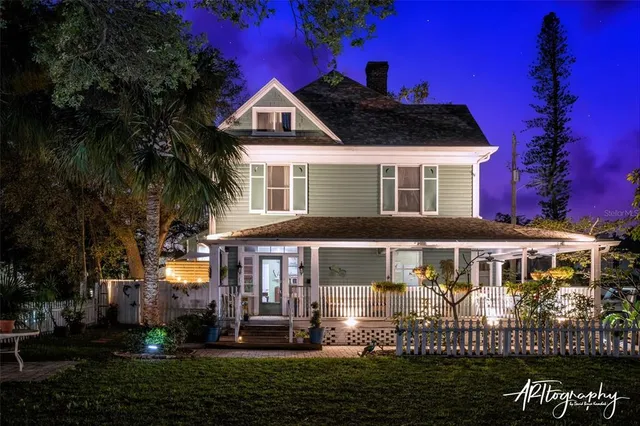 a view of a house with a small yard and wooden floor and fence