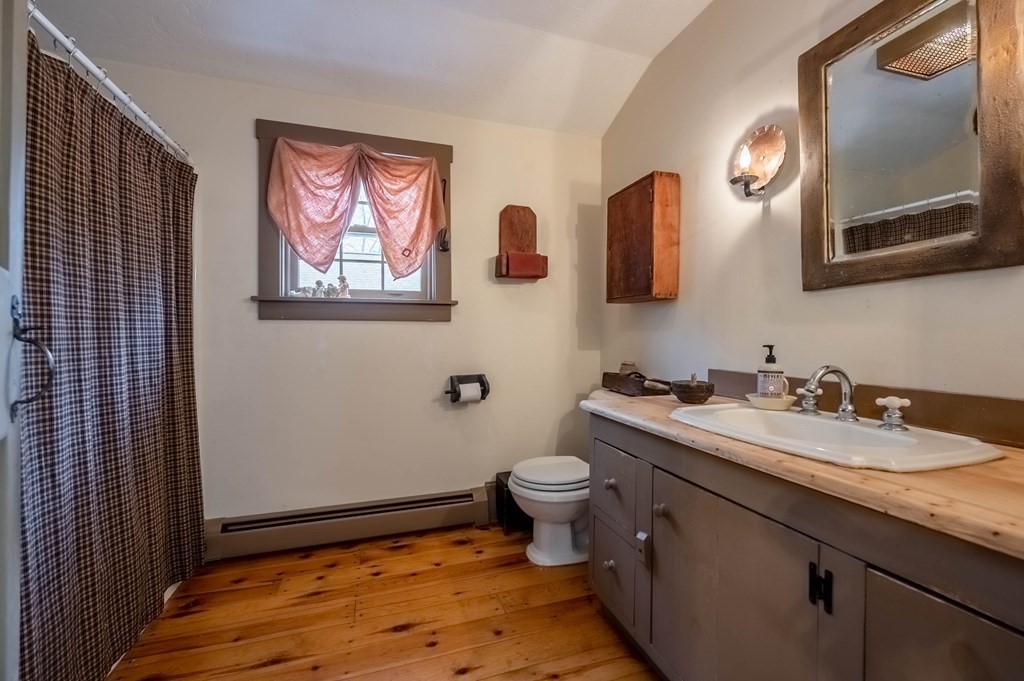 400 Main Street Boxford, MA 01921 - Photo 20 of 34 a bathroom with a granite countertop toilet a sink and a mirror
