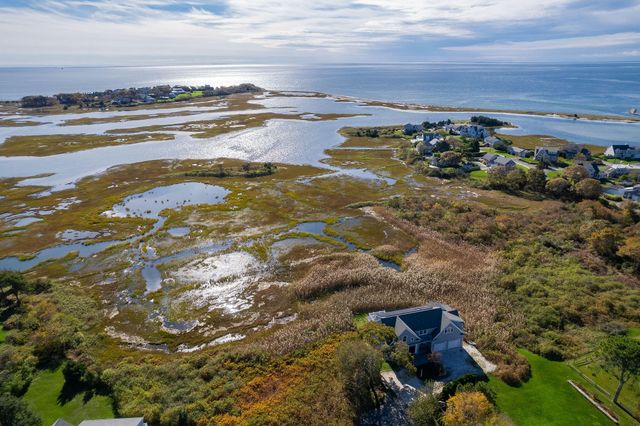 a view of a house with a yard and potted plants