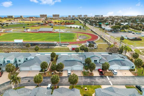 an aerial view of a building with garden space and ocean view