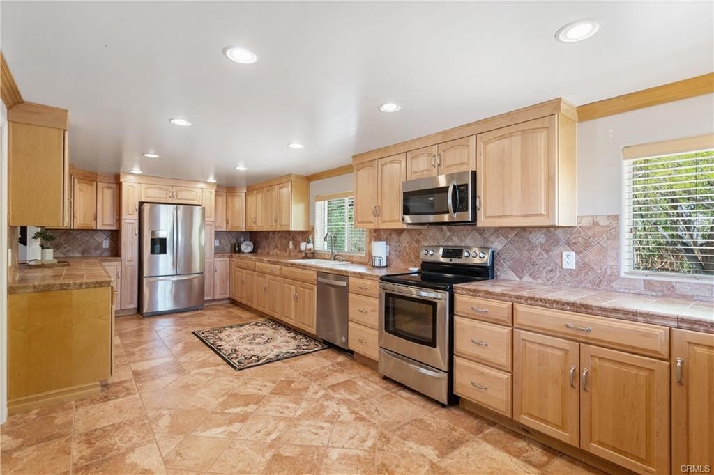 66125 Brant Cross Joshua Tree, CA 92252 - Photo 14 of 35 a kitchen with a sink a counter top space stainless steel appliances and cabinets