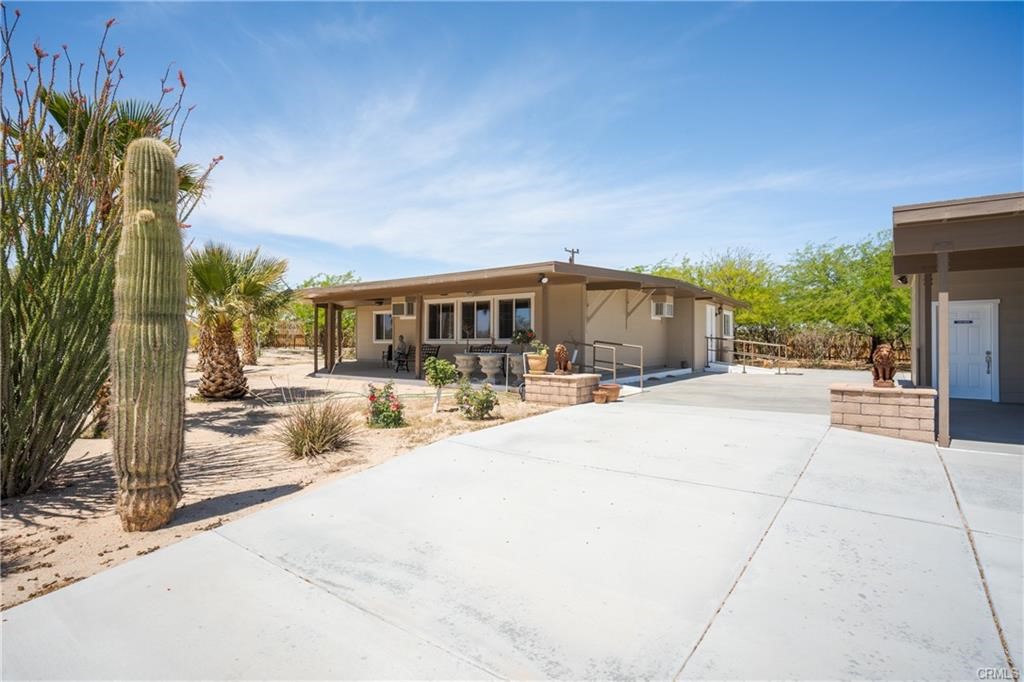 66125 Brant Cross Joshua Tree, CA 92252 - Photo 2 of 35 a view of a patio with couches and table and chairs and potted plants
