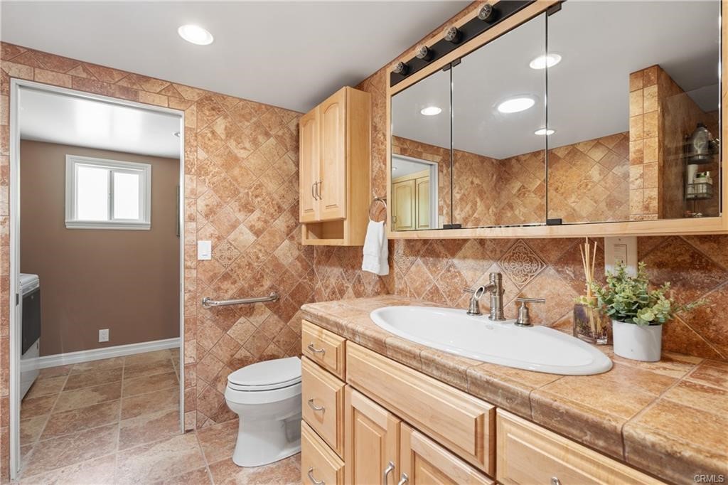 66125 Brant Cross Joshua Tree, CA 92252 - Photo 25 of 35 a bathroom with a granite countertop sink a toilet a mirror and shower