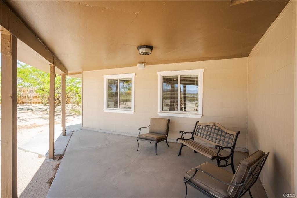 66125 Brant Cross Joshua Tree, CA 92252 - Photo 9 of 35 a living room with furniture and a floor to ceiling window