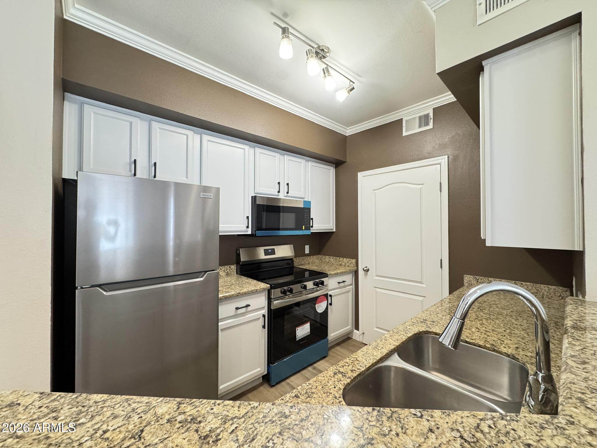 1701 East Colter Street, Unit 291 Phoenix, AZ 85016 - Photo 22 of 32 a kitchen with stainless steel appliances granite countertop a refrigerator a sink a stove a microwave and island
