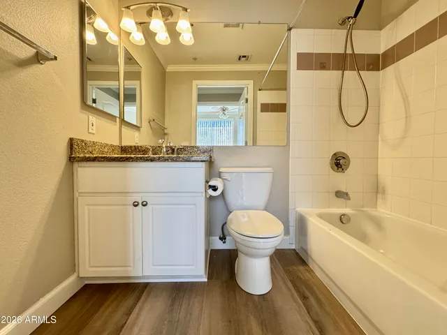 a bathroom with a granite countertop sink toilet and shower