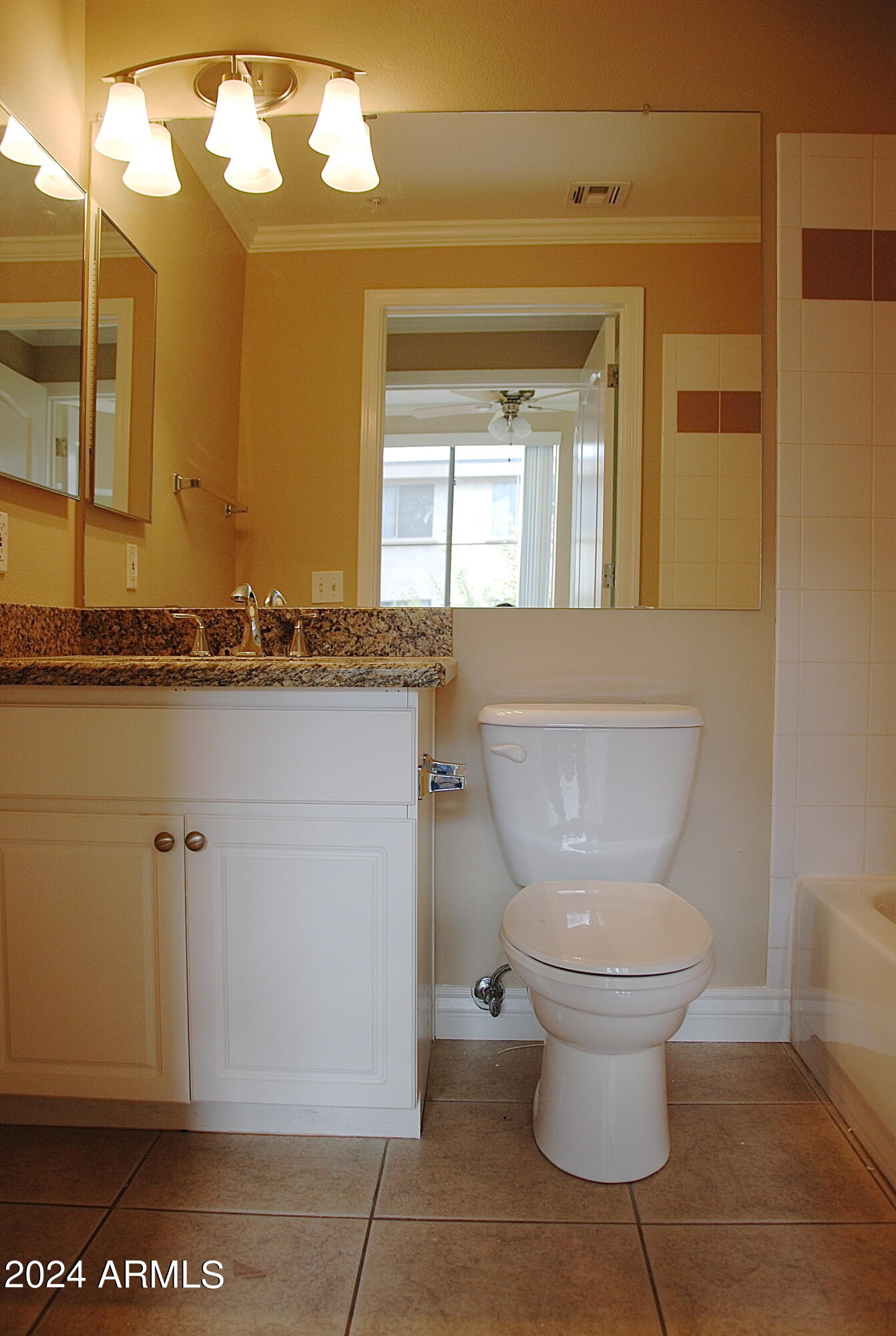 1701 East Colter Street, Unit 291 Phoenix, AZ 85016 - Photo 4 of 32 a bathroom with a granite countertop toilet a mirror and a sink