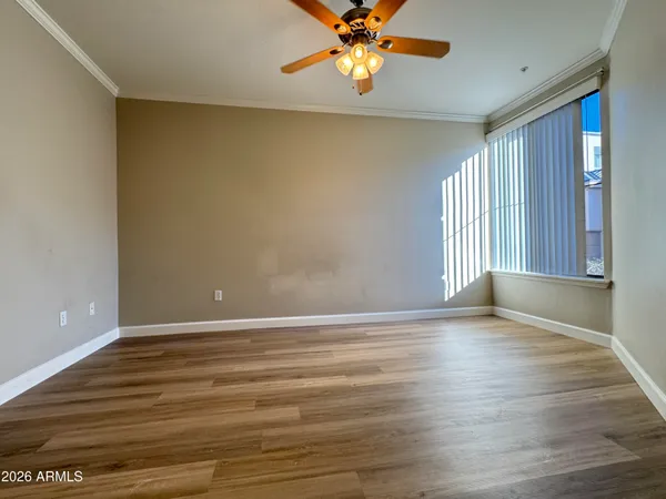 a view of an empty room with window and wooden floor