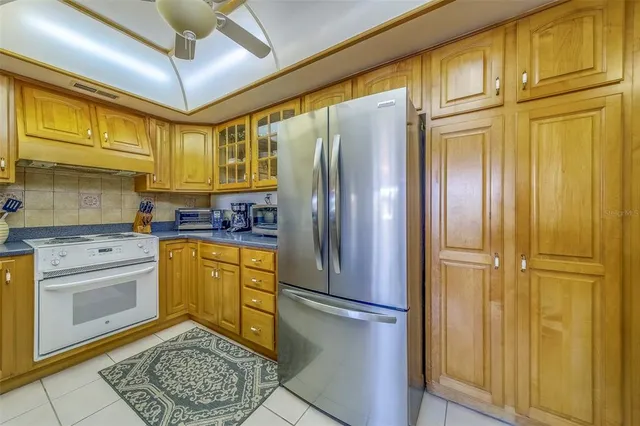 a kitchen with stainless steel appliances granite countertop a refrigerator a oven and white cabinets