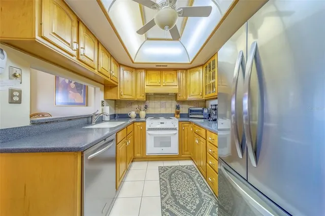 a kitchen with stainless steel appliances granite countertop sink stove and refrigerator