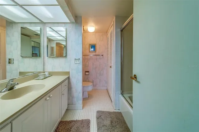a spacious bathroom with a granite countertop sink and a mirror