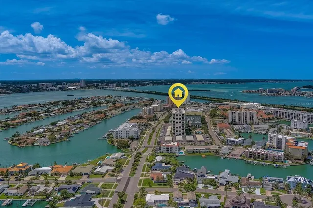 a front view of a building with glass windows and plants