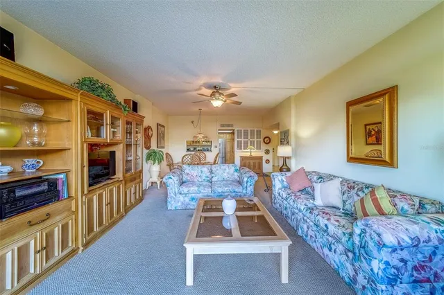 a living room with furniture a flat screen tv and a table