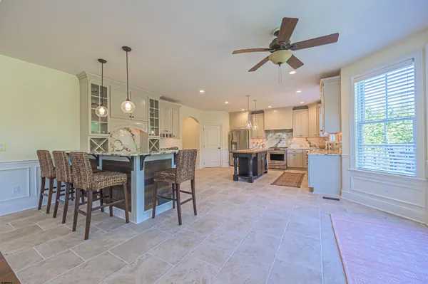 a view of a dining room and livingroom with furniture a rug a fireplace and a chandelier