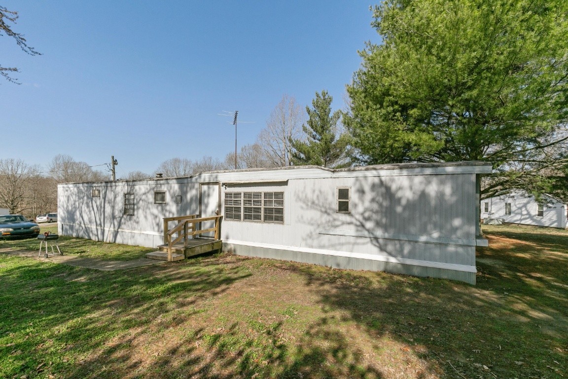 9812 Rocky Point Road Bon Aqua, TN 37025 - Photo 41 of 48 a view of a house with a yard