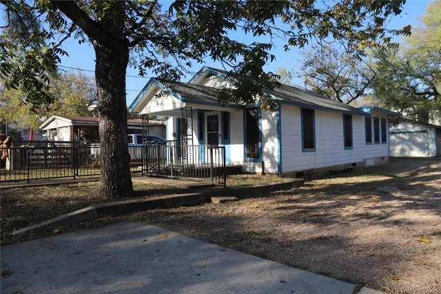 a view of a house with street next to a road