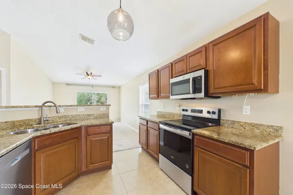 a kitchen with stainless steel appliances granite countertop a stove top oven microwave and cabinets
