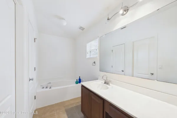 a bathroom with a tub sink and mirror