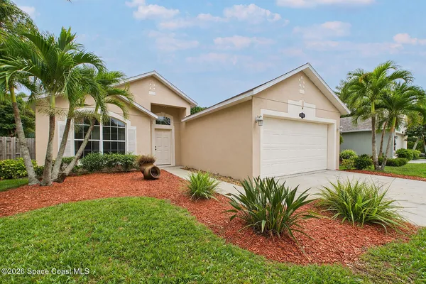 a front view of house with yard and trees around