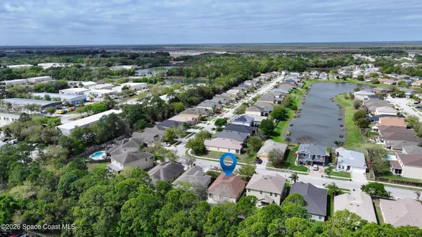 an aerial view of residential houses with outdoor space and trees