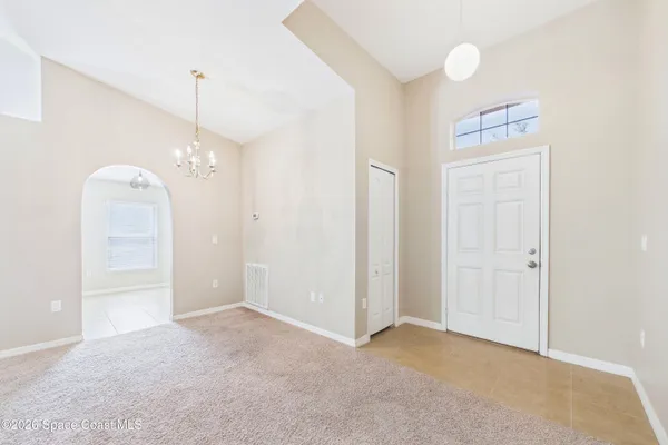a view of an empty room and window chandelier fan
