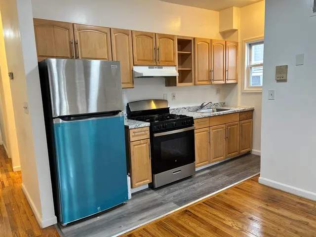 a kitchen with stainless steel appliances granite countertop a refrigerator stove and sink