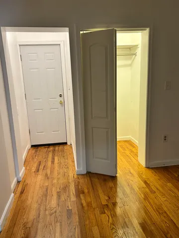 a view of a room with wooden floor and door