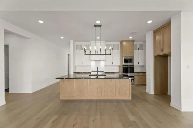 a kitchen with stainless steel appliances granite countertop a sink and a refrigerator