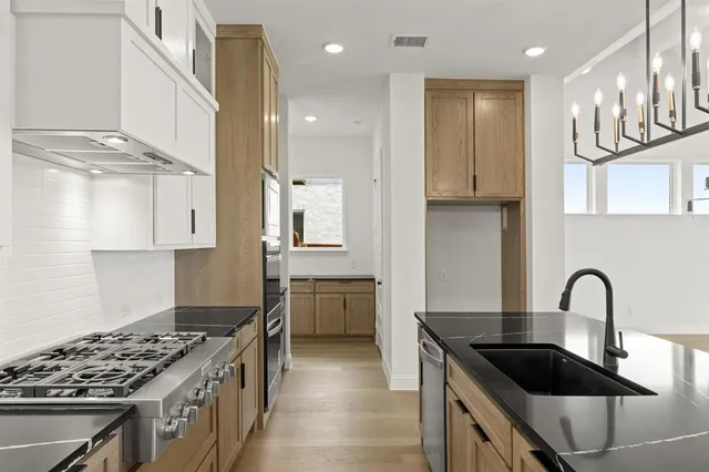 a kitchen with granite countertop a sink stove and cabinets
